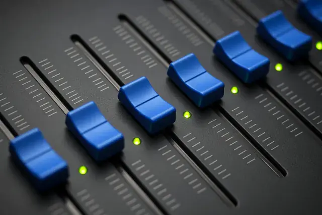 Faders on a dark desk
